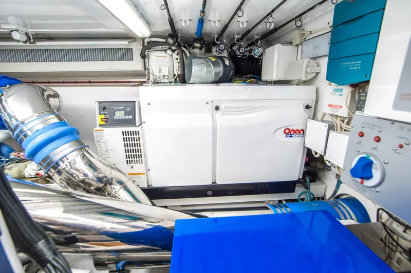 Slide: The Image of Engine room of a 2003 Donzi R65 boat, featuring Onan generator and mechanical components. - 19