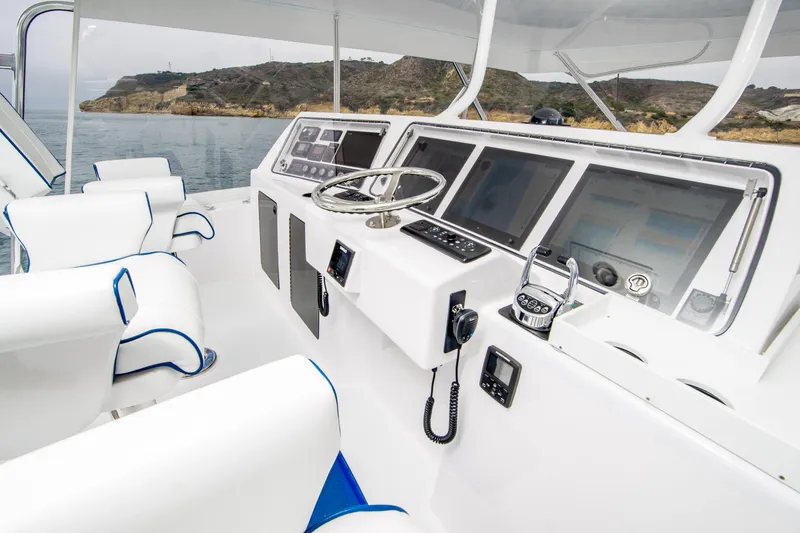 Slide: The Image of 2003 Donzi R65 yacht cockpit with modern navigation equipment and white seating. - 4