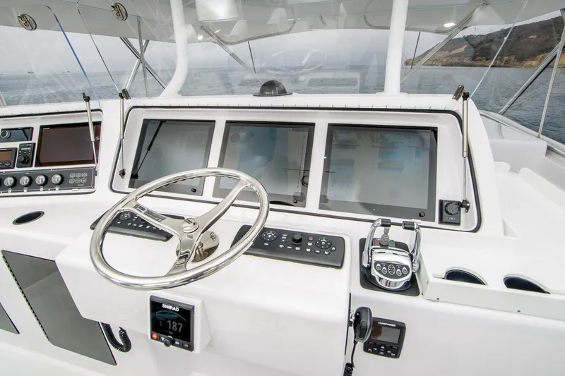 Slide: The Image of Control panel of a 2003 Donzi R65 boat with steering wheel and navigation screens. - 5
