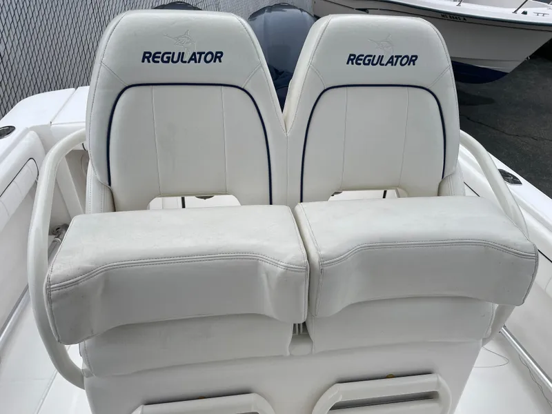 Slide: The Image of 2016 Regulator 28 boat seats with white upholstery and logo. - 10