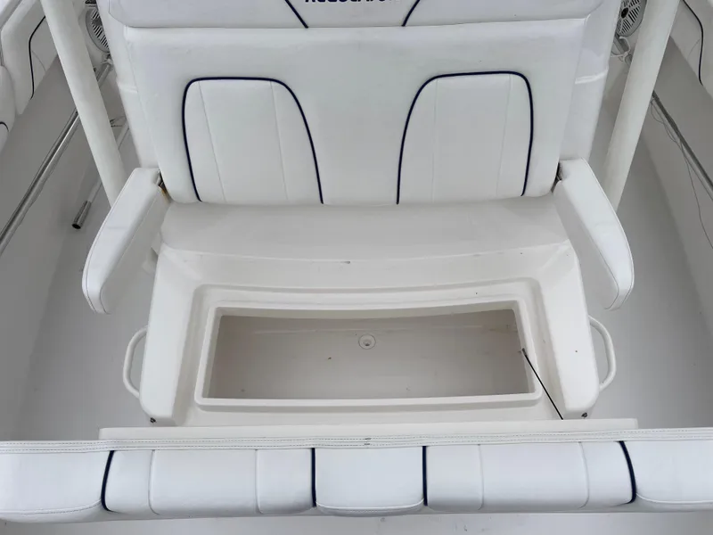 Slide: The Image of 2016 Regulator 28 boat seating with storage compartment, white upholstery. - 14