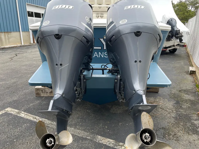 Slide: The Image of Twin outboard engines on a 2016 Regulator 28 boat, parked on asphalt. - 4