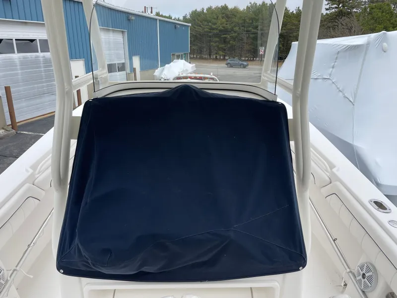 Slide: The Image of 2016 Regulator 28 boat with covered console, docked near blue building. - 9