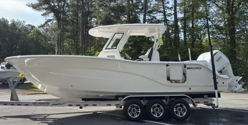 Slide: The Image of 2025 Sea Fox 288 Commander boat on a serene lake with lush green trees. - 0