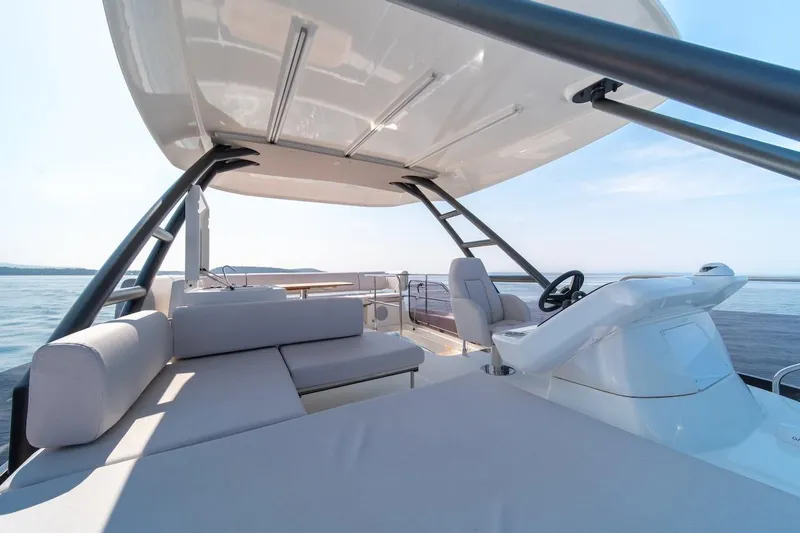 Slide: The Image of Luxurious 2025 Prestige F4.9 yacht interior with modern seating and steering, overlooking serene waters. - 23