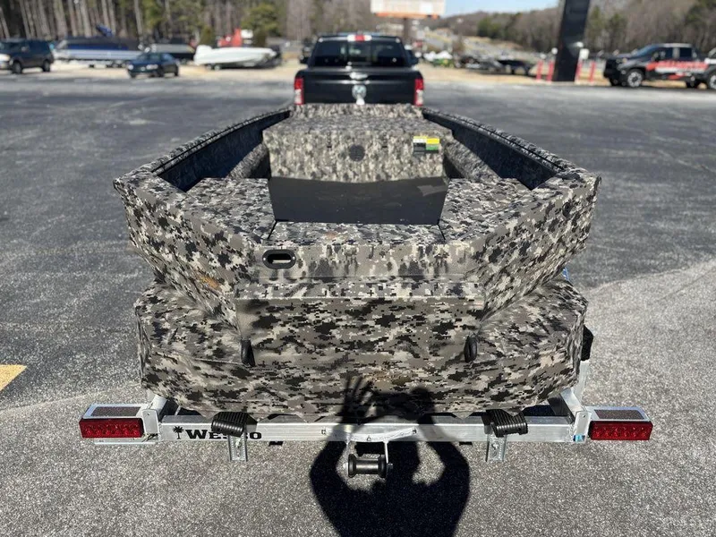 Slide: The Image of 2025 Havoc RDBST 1553 boat on trailer, camo design, parked outdoors. - 4