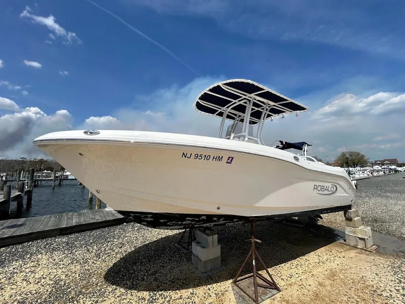 Slide: The Image of 2019 Robalo R202EX boat on display at a marina under a clear sky. - 0