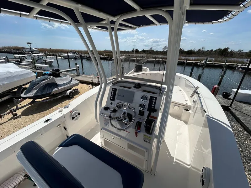 Slide: The Image of 2019 Robalo R202EX boat interior with steering console, docked at marina. - 10