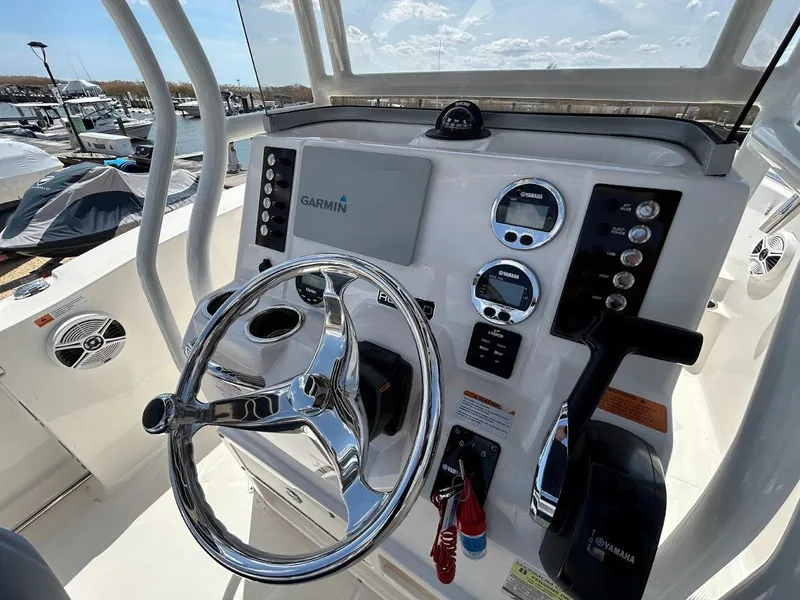 Slide: The Image of 2019 Robalo R202EX boat dashboard with Garmin navigation system and chrome steering wheel. - 11