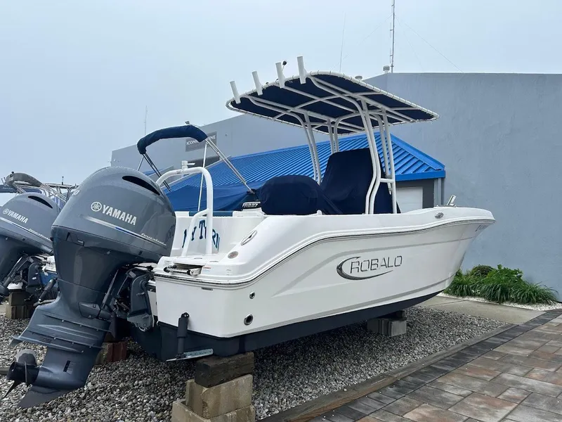 Slide: The Image of 2019 Robalo R202EX boat with Yamaha engine, displayed outdoors on a stand. - 21