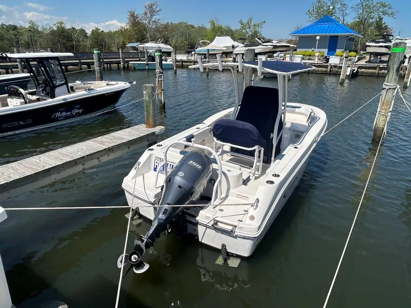 Slide: The Image of 2019 Robalo R202EX boat docked in a marina with outboard motor. - 7