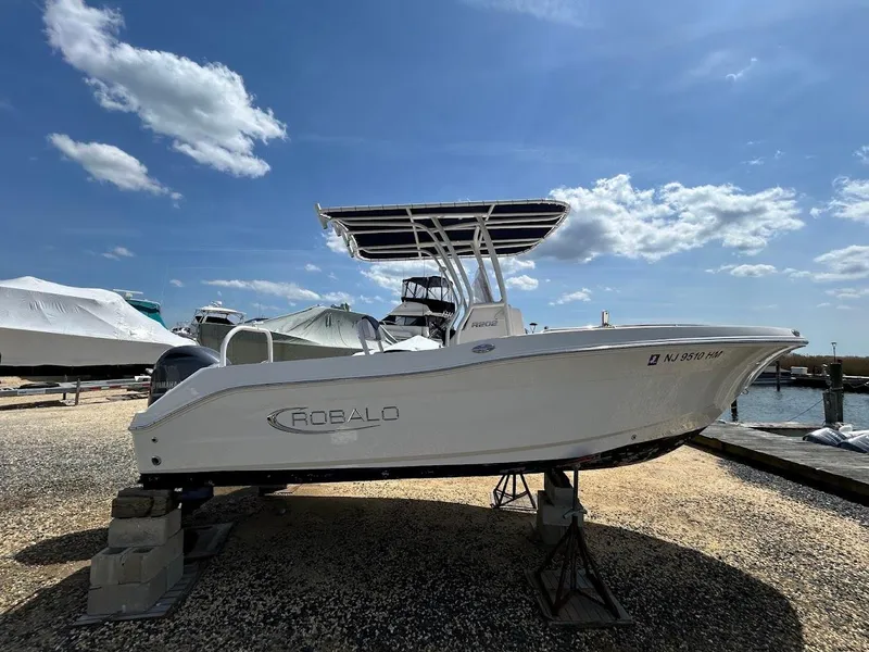 Slide: The Image of 2019 Robalo R202EX boat on stands, clear sky background, marina setting. - 8