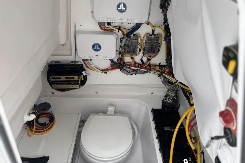 Slide: The Image of 2025 Sportsman Heritage 231 boat interior with wiring and marine toilet setup. - 20