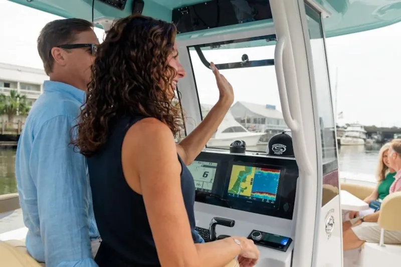 Slide: The Image of Couple enjoying a ride on a 2025 Sportsman Heritage 231 boat, with advanced navigation system. - 24