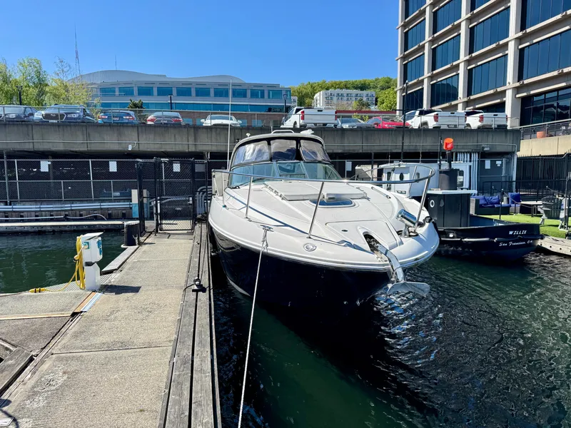 Slide: The Image of 2009 Sea Ray 350 Sundancer docked at a marina, urban backdrop. - 1