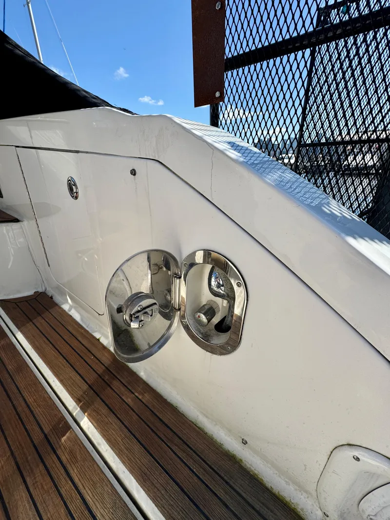 Slide: The Image of 2009 Sea Ray 350 Sundancer boat deck with polished metal fixtures and wooden flooring. - 11