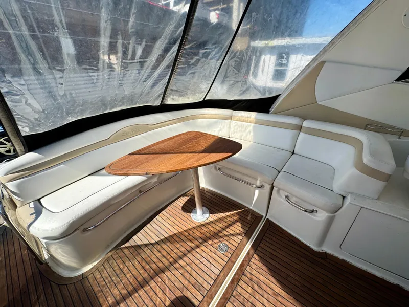 Slide: The Image of 2009 Sea Ray 350 Sundancer interior with white seating and wooden table. - 12