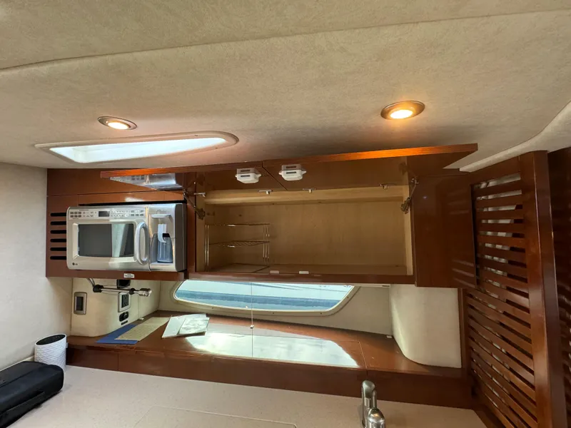 Slide: The Image of Interior of 2009 Sea Ray 350 Sundancer with open cabinet, microwave, and window. - 23