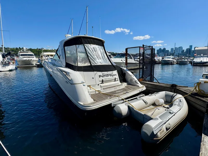 Slide: The Image of 2009 Sea Ray 350 Sundancer yacht docked with inflatable boat, sunny marina view. - 5