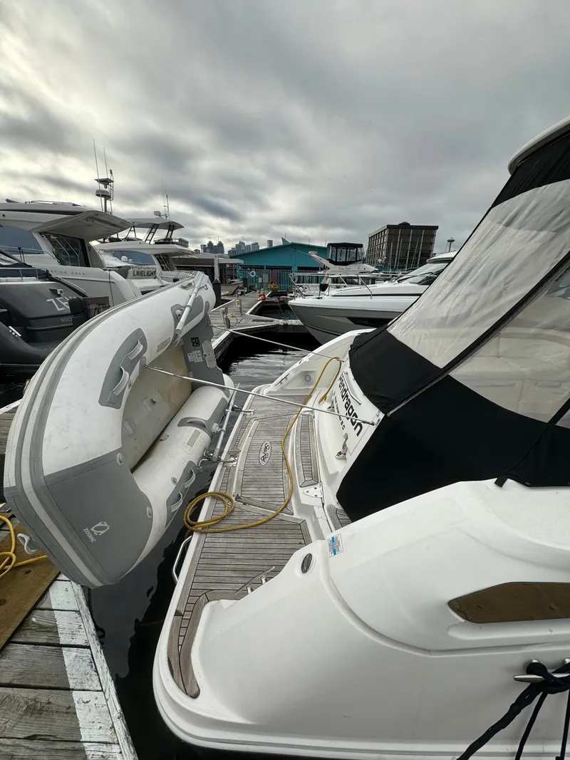 Slide: The Image of 2009 Sea Ray 350 Sundancer docked with inflatable boat, overcast sky. - 6