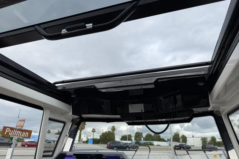 Slide: The Image of 2026 Navan C30 boat with open sunroof, showcasing interior and cloudy sky. - 25