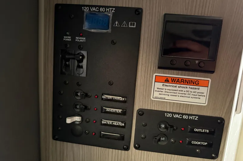 Slide: The Image of Electrical control panel of 2026 Navan C30 with warning label and switches. - 36