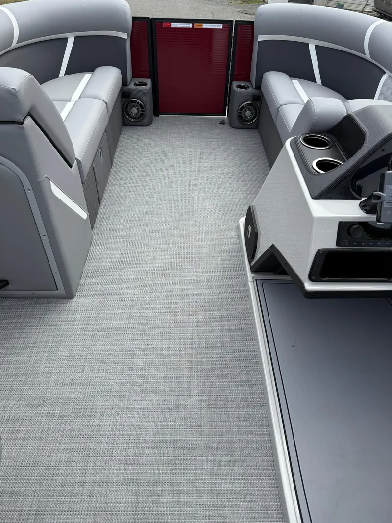 Slide: The Image of 2025 Crest 220 SLRC boat interior with gray seating and carpet, featuring cup holders and speakers. - 16