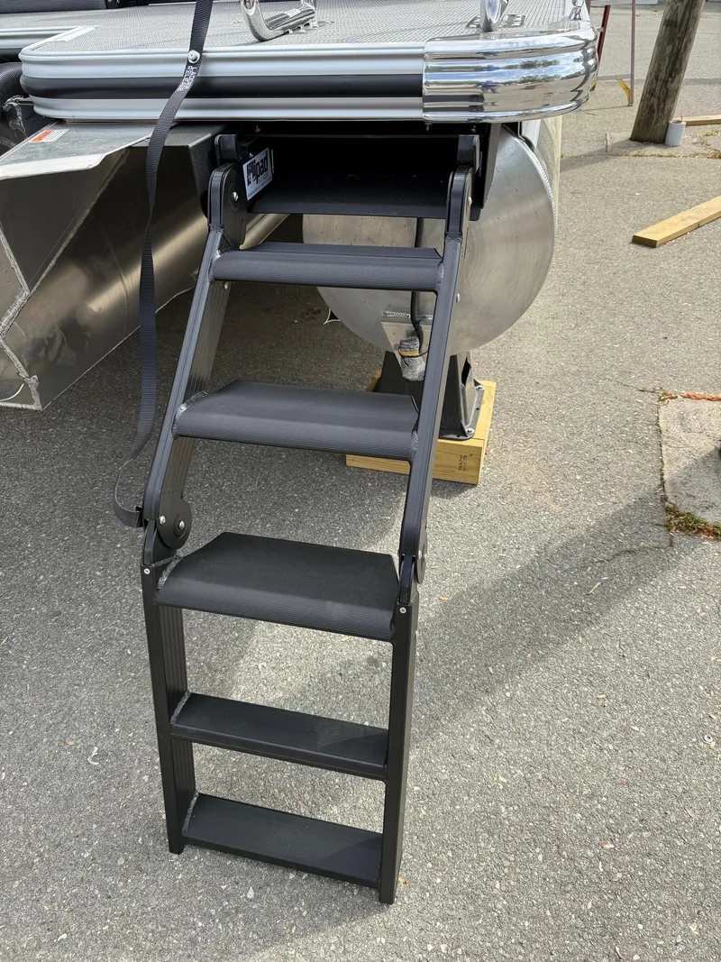 Slide: The Image of 2025 Crest 220 SLRC boat ladder, black steps, docked on pavement. - 26