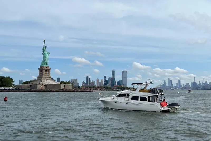 Slide: The Image of Navigator 4800 CLASSIC yacht near Statue of Liberty, New York City skyline in background. - 0