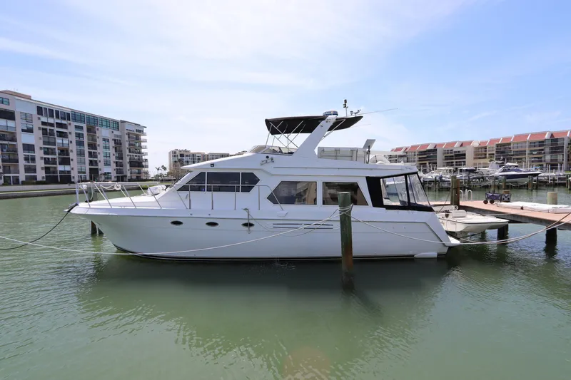 Slide: The Image of 2001 Navigator 4800 CLASSIC yacht docked in a marina with waterfront buildings. - 2