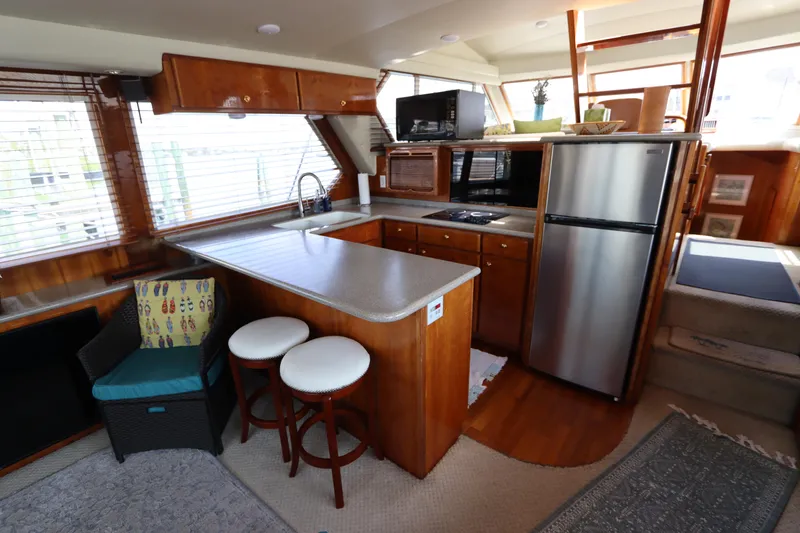 Slide: The Image of 2001 Navigator 4800 CLASSIC yacht interior with kitchen, bar stools, and modern appliances. - 22
