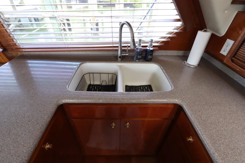 Slide: The Image of Kitchen sink area in 2001 Navigator 4800 CLASSIC yacht with wooden cabinetry and countertop. - 24
