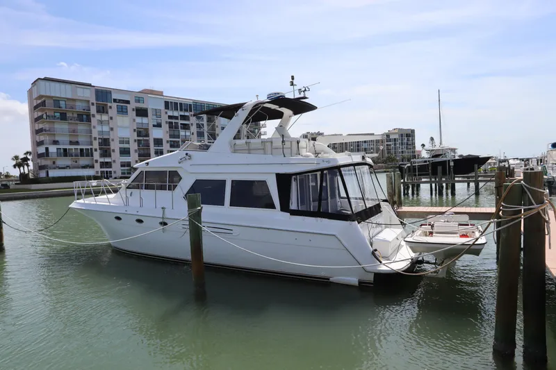 Slide: The Image of Navigator 4800 CLASSIC yacht docked in marina, 2001 model, with modern buildings in background. - 3