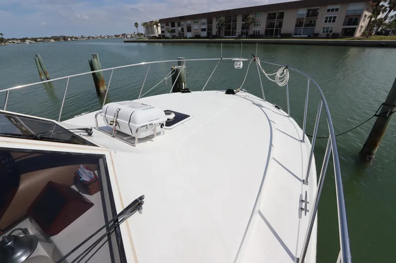 Slide: The Image of 2001 Navigator 4800 CLASSIC yacht docked in a serene waterfront setting. - 4