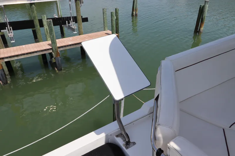 Slide: The Image of Navigator 4800 CLASSIC 2001 boat with white seating and table, docked by wooden piers. - 44