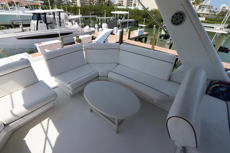 Slide: The Image of Spacious seating area on 2001 Navigator 4800 CLASSIC yacht, featuring white cushioned seats and table. - 47