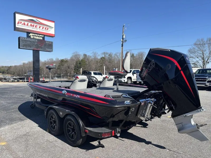 Slide: The Image of 2025 Phoenix 721 ZXL boat on trailer at dealership, featuring sleek black and red design. - 4