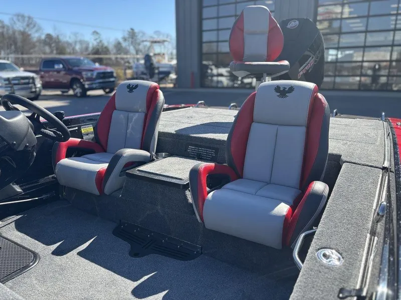 Slide: The Image of 2025 Phoenix 721 ZXL boat interior with red and gray seats, parked outdoors. - 8