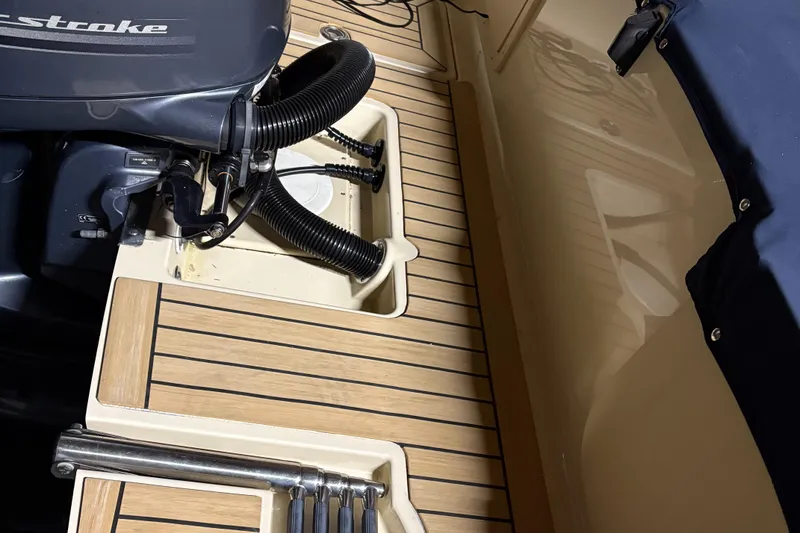 Slide: The Image of 2017 Rossiter 20 Coastal Cruiser boat deck with motor and wooden flooring. - 11