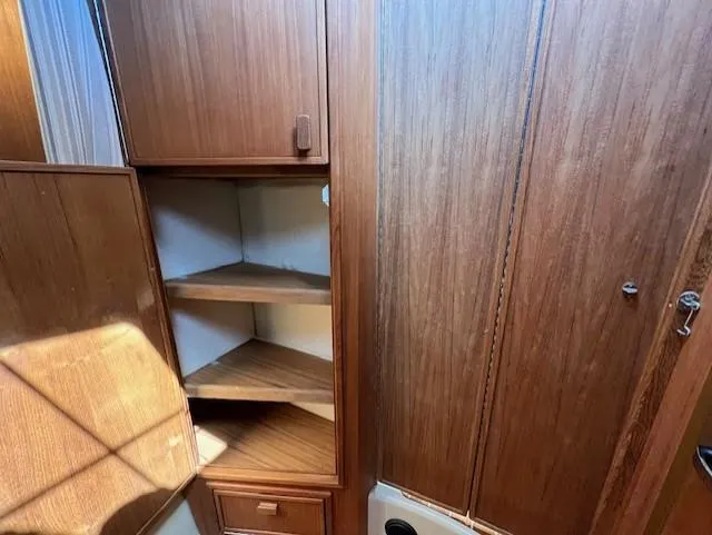 Slide: The Image of 2020 Ranger Tugs R-31 CB interior with wooden cabinetry and corner shelves. - 19