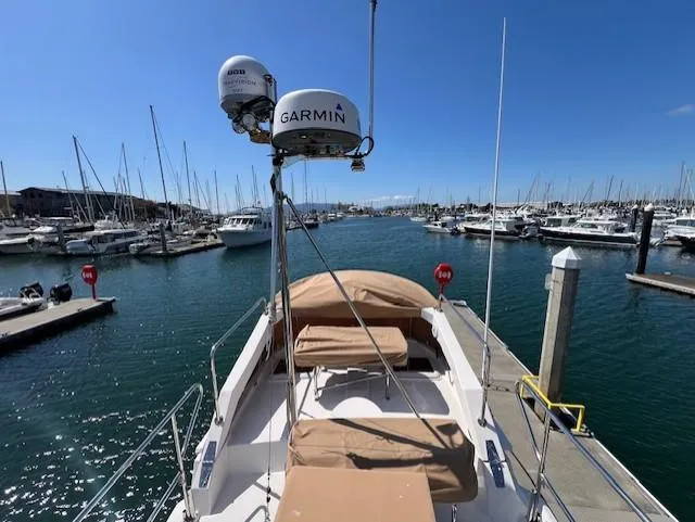 Slide: The Image of 2020 Ranger Tugs R-31 CB docked in a marina, surrounded by boats under a clear blue sky. - 23