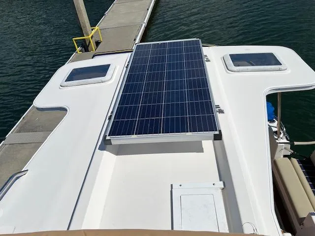 Slide: The Image of 2020 Ranger Tugs R-31 CB with solar panel on deck, docked by water. - 25