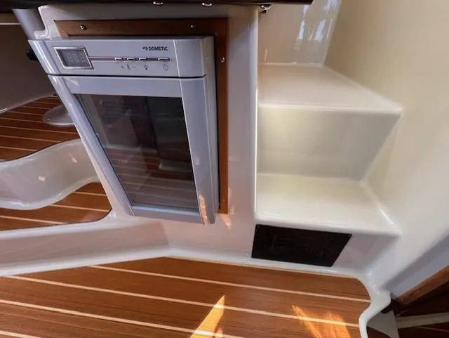 Slide: The Image of 2020 Ranger Tugs R-31 CB interior with Dometic fridge and wooden flooring. - 28