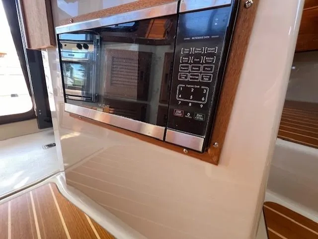 Slide: The Image of 2020 Ranger Tugs R-31 CB interior microwave with control panel and wood accents. - 29