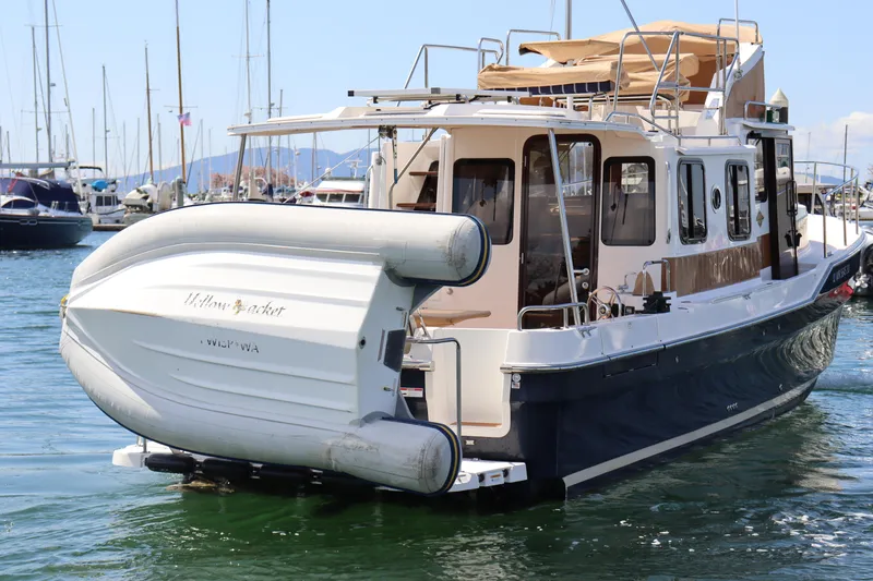 Slide: The Image of 2020 Ranger Tugs R-31 CB boat with dinghy, docked in a marina. - 3