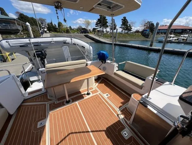 Slide: The Image of 2020 Ranger Tugs R-31 CB boat deck with seating and table, docked by the water. - 5