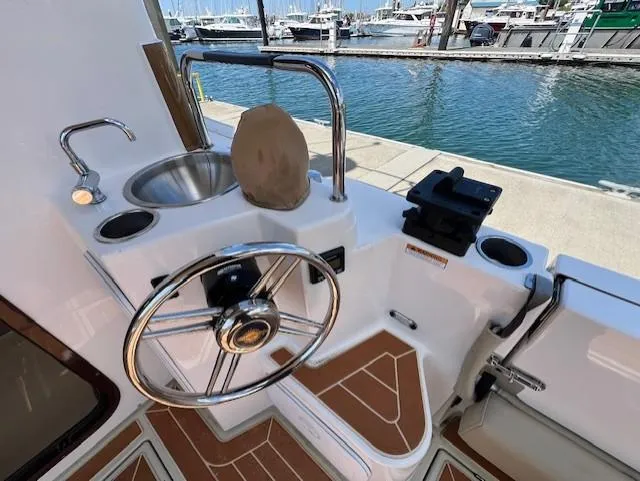 Slide: The Image of Cockpit of 2020 Ranger Tugs R-31 CB with steering wheel and sink, dockside view. - 6