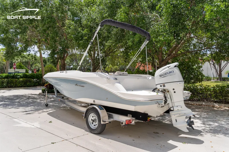 Slide: The Image of 2021 Hurricane SS 205 boat on trailer with Suzuki outboard motor, parked outdoors. - 2