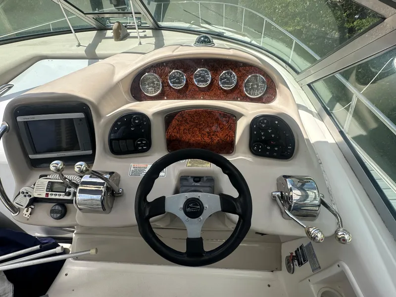 Slide: The Image of 2004 Sea Ray 340 Sundancer helm with gauges, steering wheel, and control panel. - 20