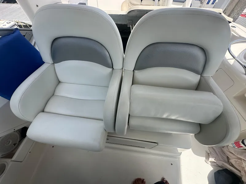 Slide: The Image of 2004 Sea Ray 340 Sundancer boat seats, white and gray upholstery, cockpit view. - 23